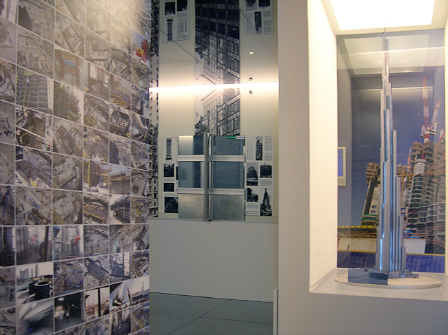 Gallery view of the presentation model case and wall with a grid of construction photographs