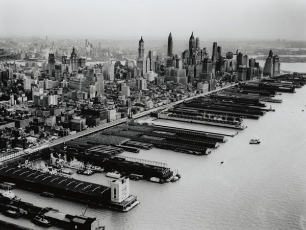 Aerial view of West Street and Hudson Yards in the foreground and the skyline of Lower Manhattan in the background