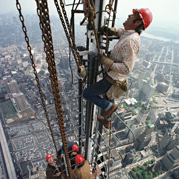 Photograph of construction workers climbing the antenna of the North Tower of the World Trade Center. Photograph by Peter B. Kaplan