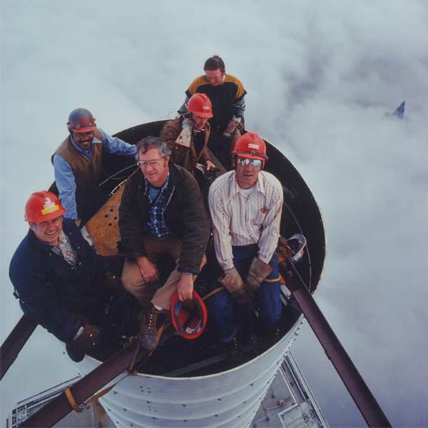 Photograph of the construction crew atop of the antenna of the World Trade Center on a cloudy day. Photograph by Peter B. Kaplan